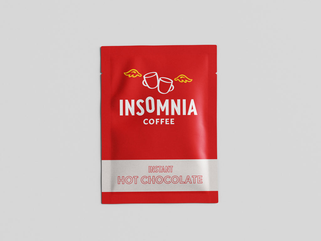 A red stand-up pouch of Insomnia Coffee Instant Hot Chocolate, featuring white text and a white band at the bottom, centered on a light gray background.