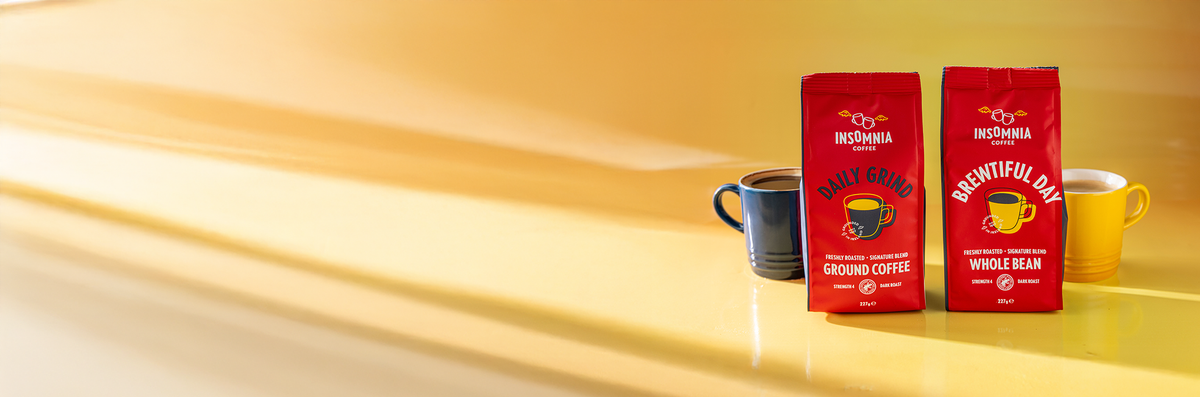 Two red coffee bags with a yellow mug on a yellow background